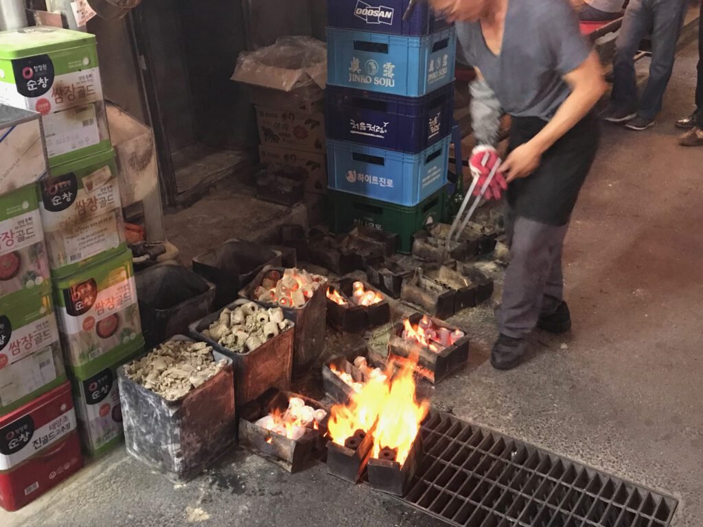 Stoking the coals at an outdoor Korean BBQ eatery in Insadong.