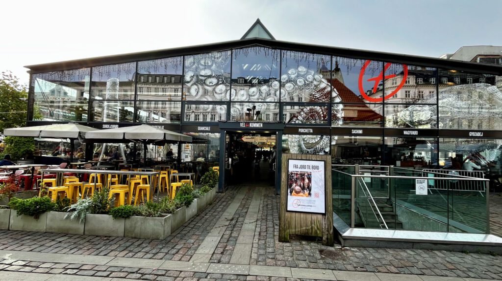 Copenhagen on a budget – Torvehallerne Food Market, Copenhagen – a perfect place to enjoy snacks, simple meals, or enjoy a glass or wine for lunch or dinner. Fresh flowers and vegetables are also available.