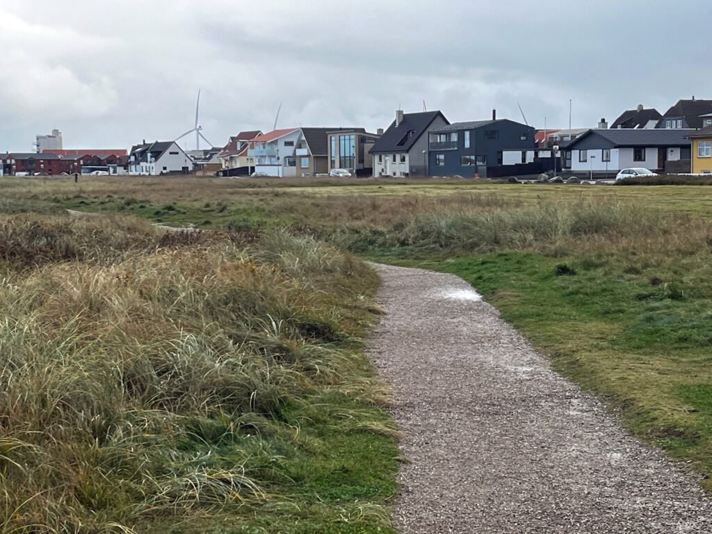 Walking along the beachfront at Hirtshals, Denmark, houses line the street.